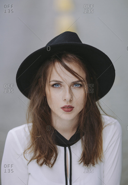 Portrait of blue eyed young woman wearing black hat