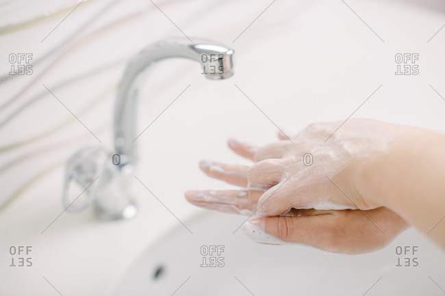 Woman washes her hands by surgical hand washing method.