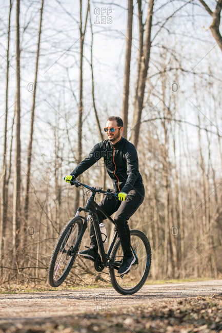 Male mountain biker riding through woods