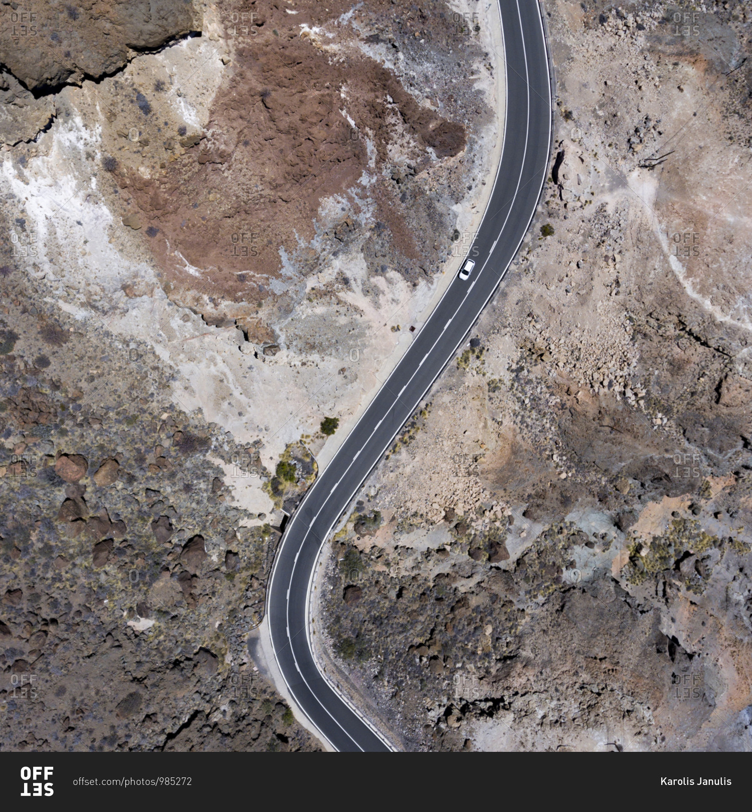 Bird\'s eye view of a car driving on a mountain road