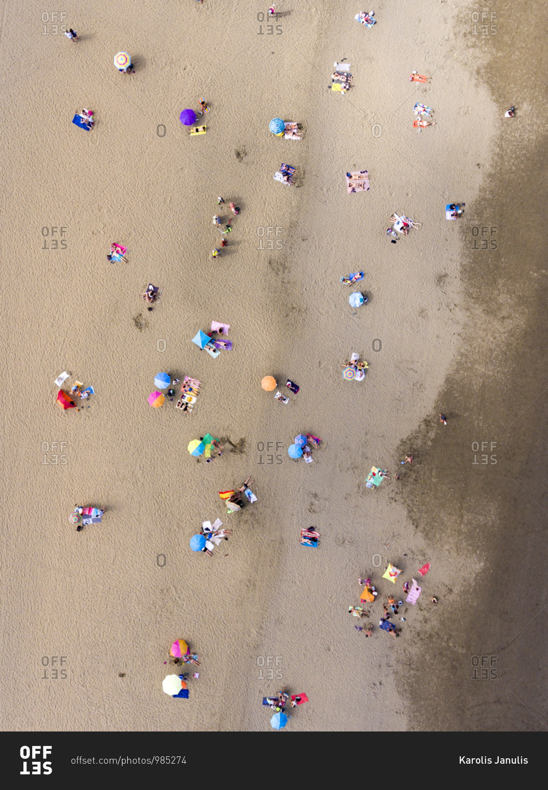 Beach filled with people and colorful umbrellas from a bird's eye view