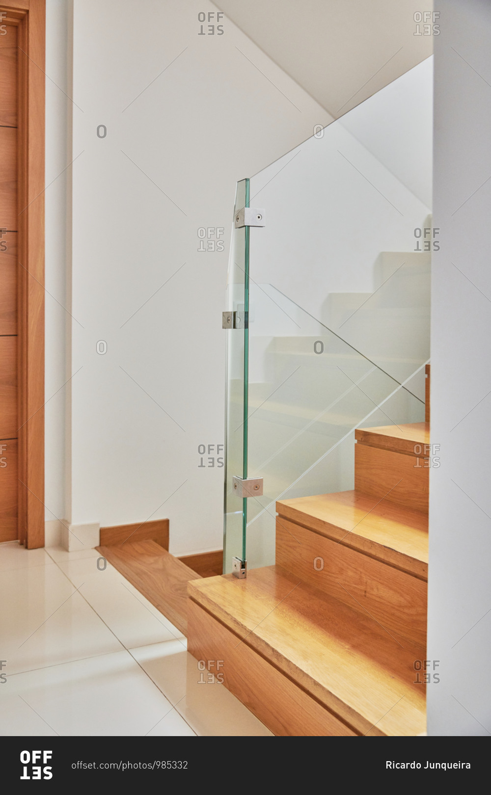 Internal wooden staircase with a glass railing