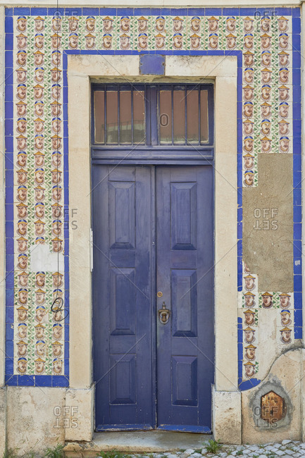 Blue door surrounded by Moorish tile on a home, Lapa neighborhood, Lisbon, Portugal