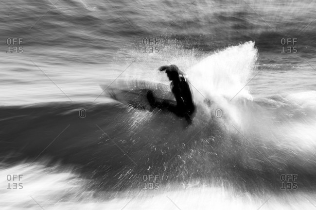 Tofino, British Columbia, Canada - April 1, 2020: Blurred action shot of surfer riding waves in the ocean
