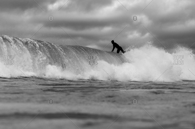 Surfer riding a wave in black and white