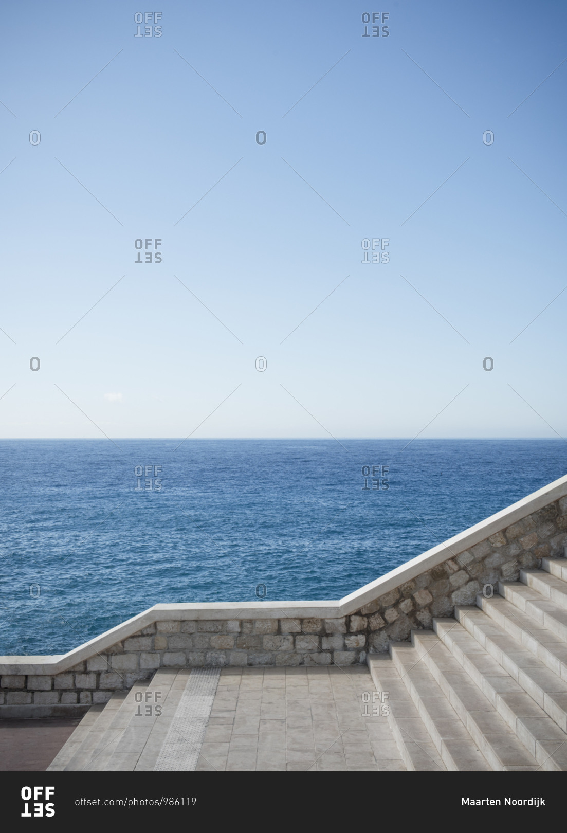 The waters of the Mediterranean sea and the promenade with stairs in the city of Nice on the d\'Azur in France.