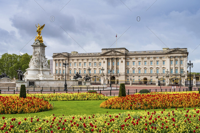 United Kingdom, England, London, Buckingham Palace, facade of the palace in Spring showing the flower gardens and the Victoria Memorial
