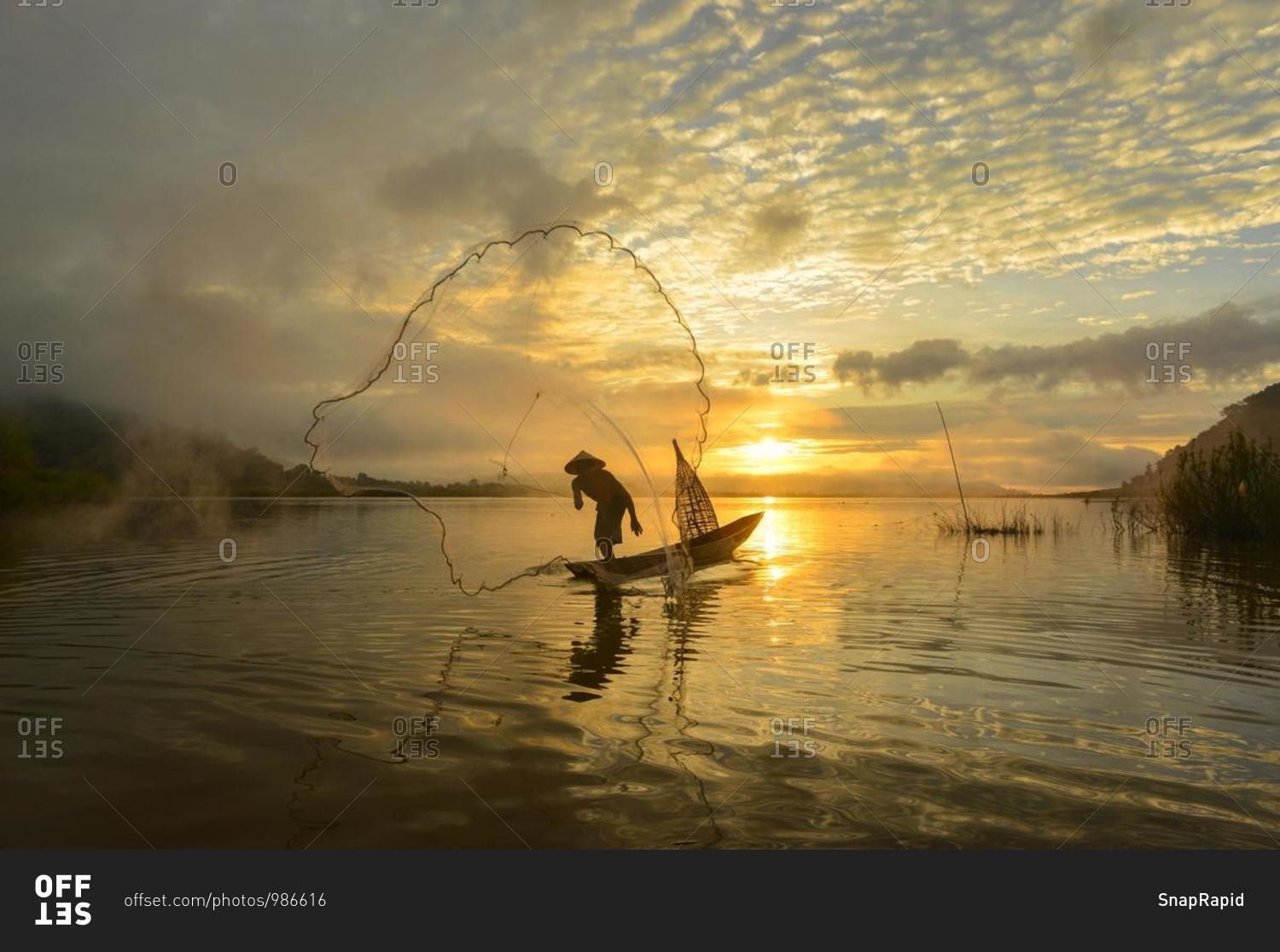 Silhouette of a man throwing fishing net, Mekong river, Sangkhom, Thailand