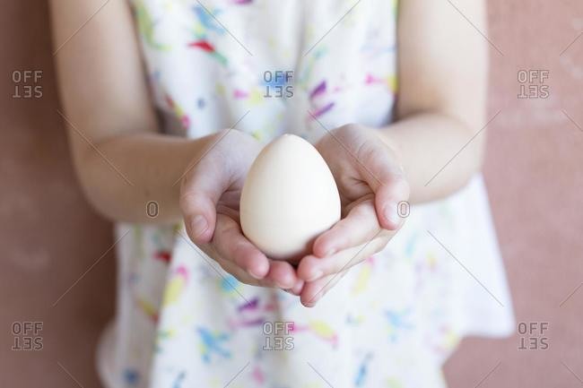 Girl holding an egg in her hands