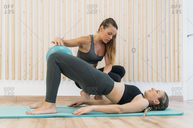 Woman exercising with coach at health club