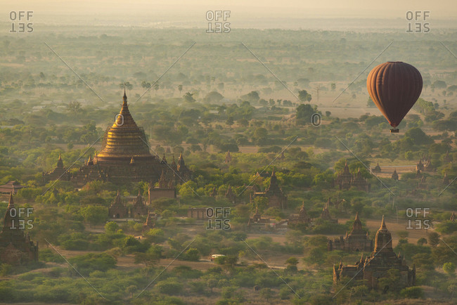 Myanmar- Mandalay Region- Bagan- Hot air balloon flying over Buddhist temples at dawn