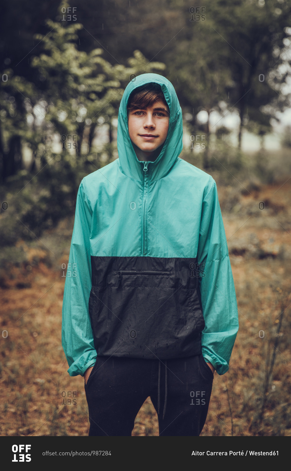 Teenager wearing raincoat in the woods