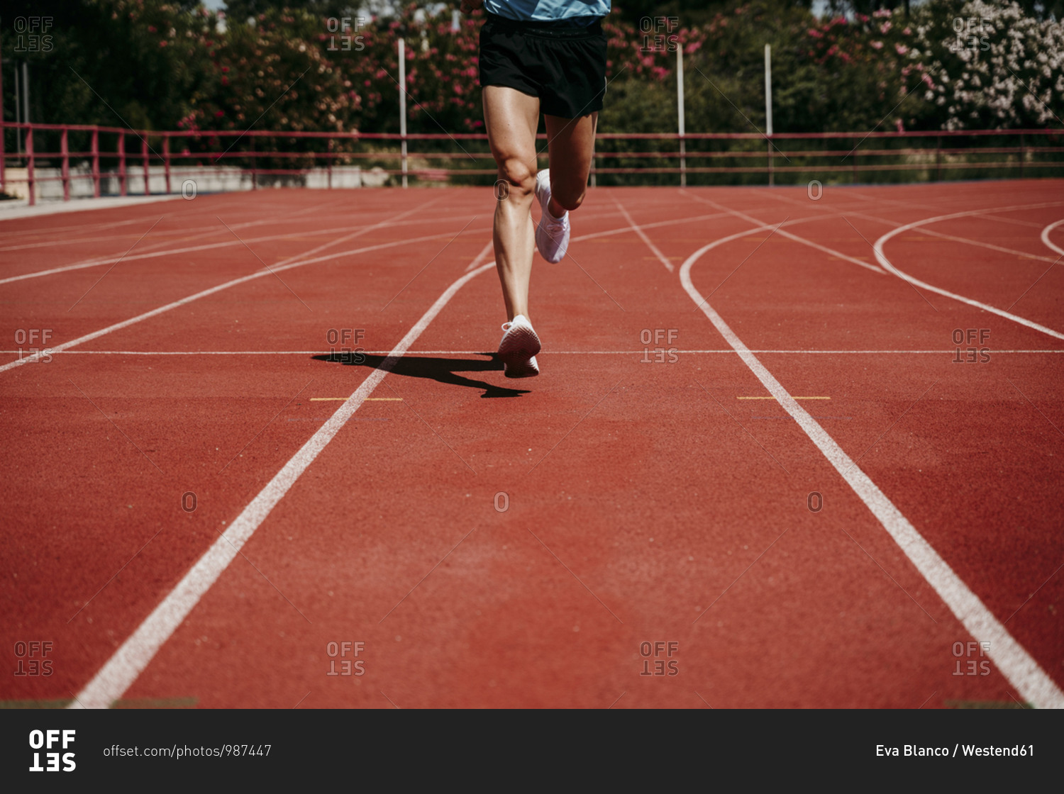 Legs of a man running on tartan track