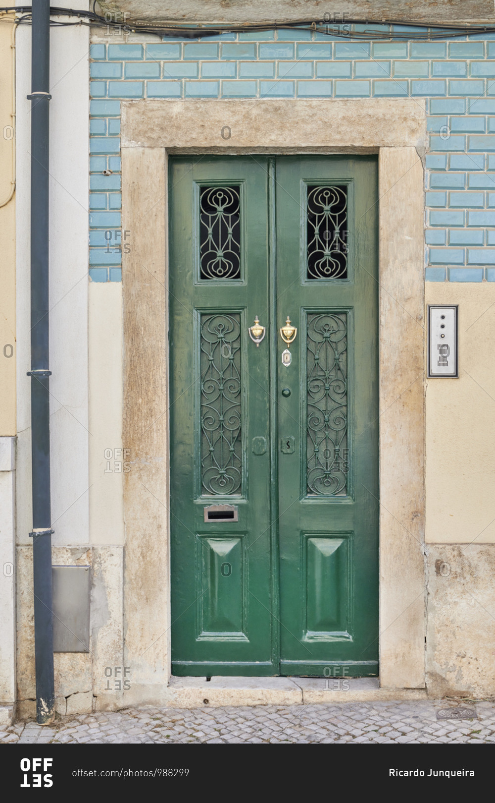 Dark green door on a home with blue tile in the Lapa neighborhood, Lisbon, Portugal