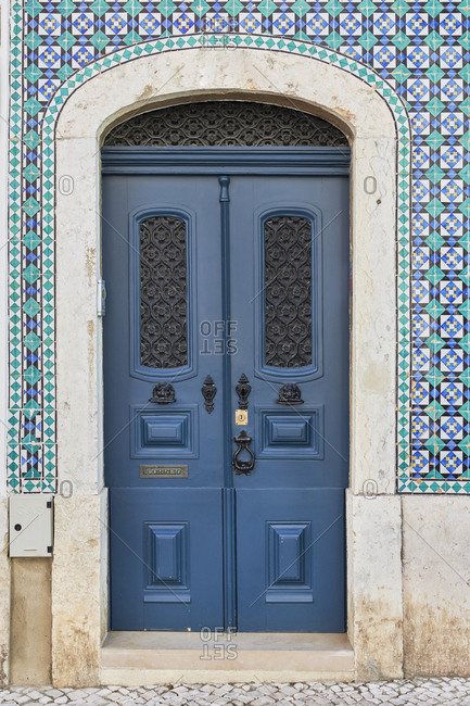 Decorative blue door on a home with Moorish tile in the Lapa neighborhood, Lisbon, Portugal