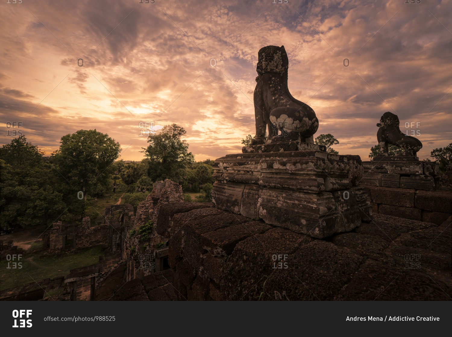Spectacular scenery of traditional Buddhist temple with monuments of animals on background of magnificent sundown in Cambodia