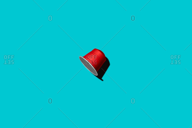 Top view of red coffee pod placed on blue background