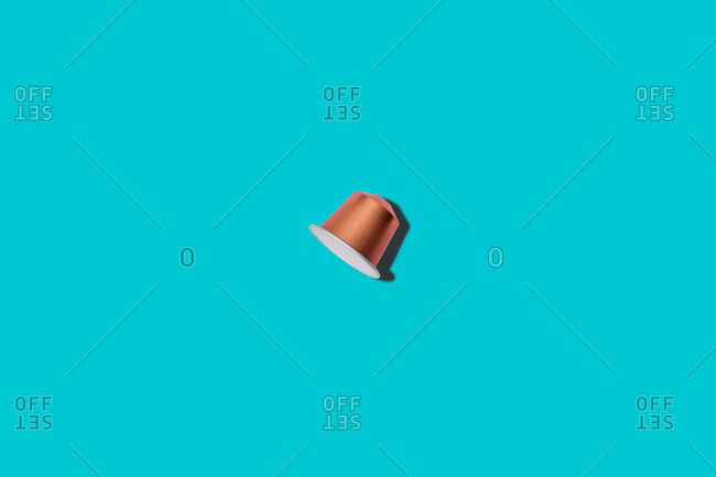 Top view of brown coffee pod placed on blue background