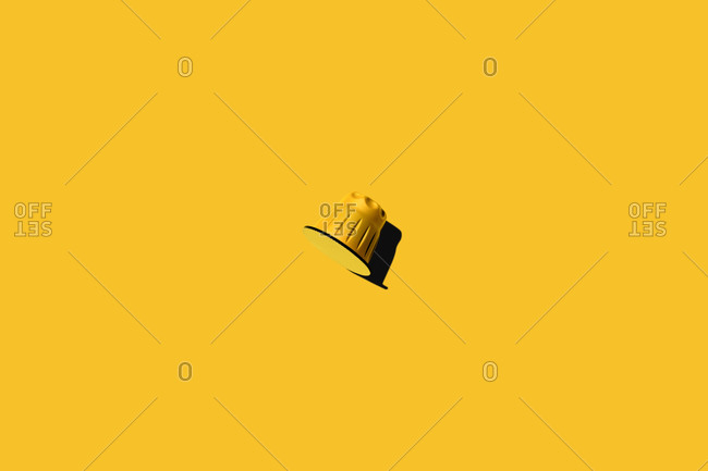 Top view of yellow coffee pod placed on yellow background