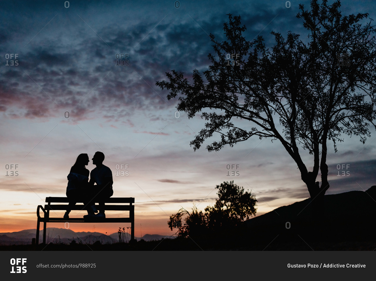 Back view silhouettes of affectionate couple enjoying romantic date