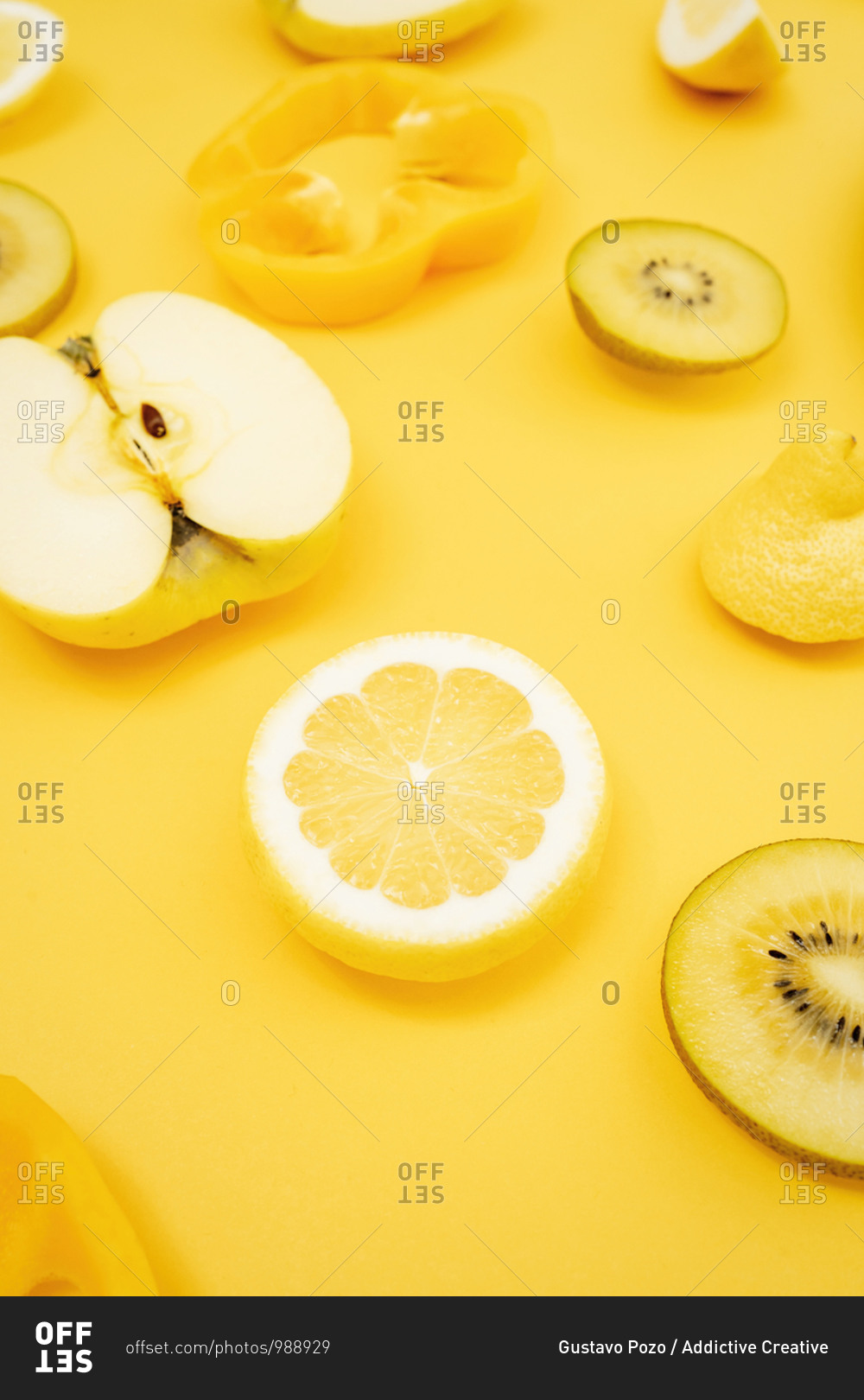 Top view of various fresh fruits and vegetables arranged on yellow background
