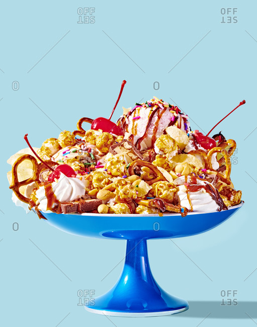 Ice Cream Sundae Topped With Junk Food on Blue Background