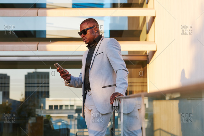 African American businessman with mobile phone on a summer afternoon.