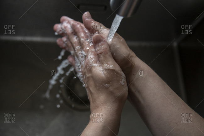 Close up of someone rinsing hands in the sink