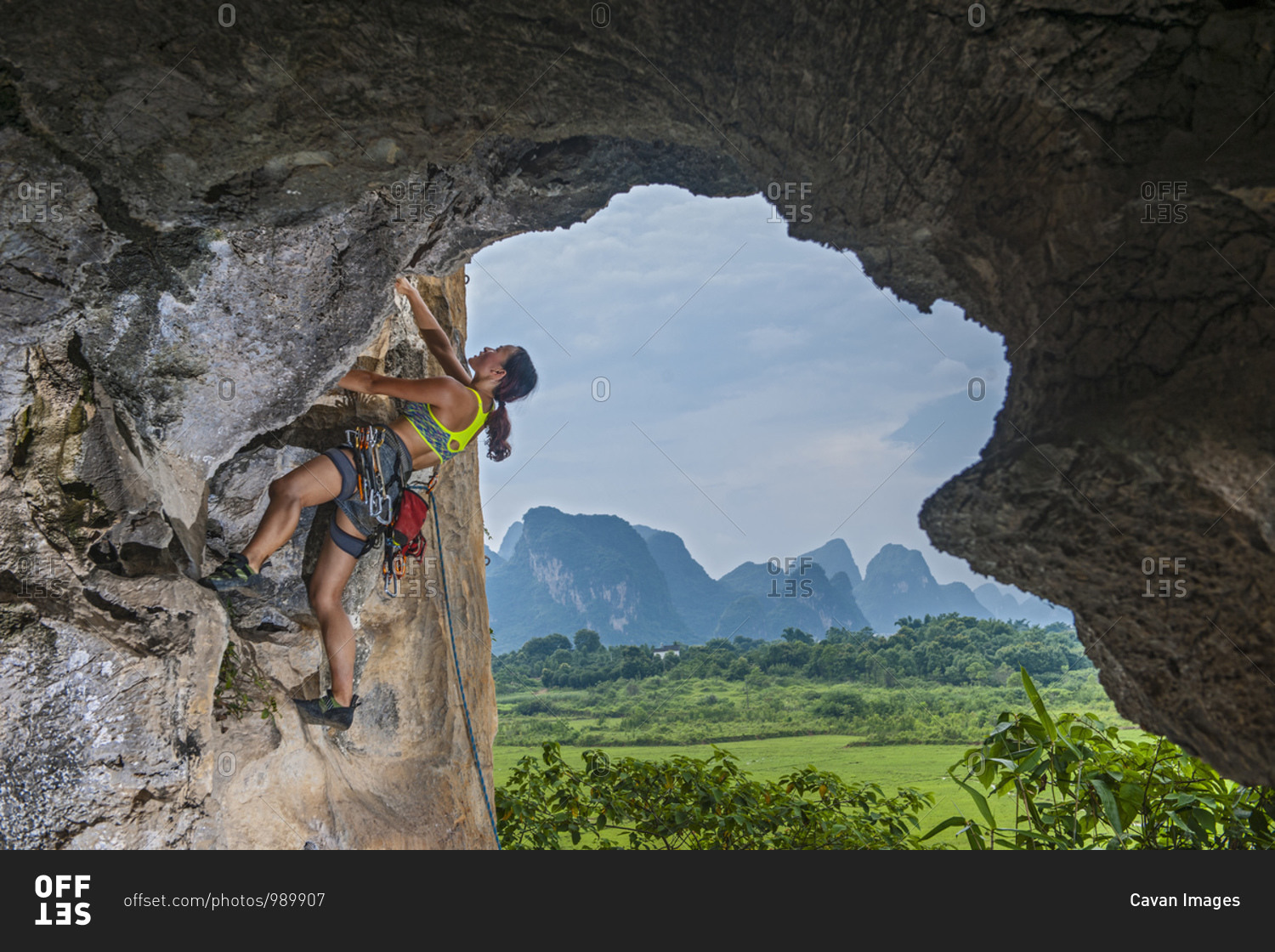 young female climber climbing at remote area in Yangshuo, China