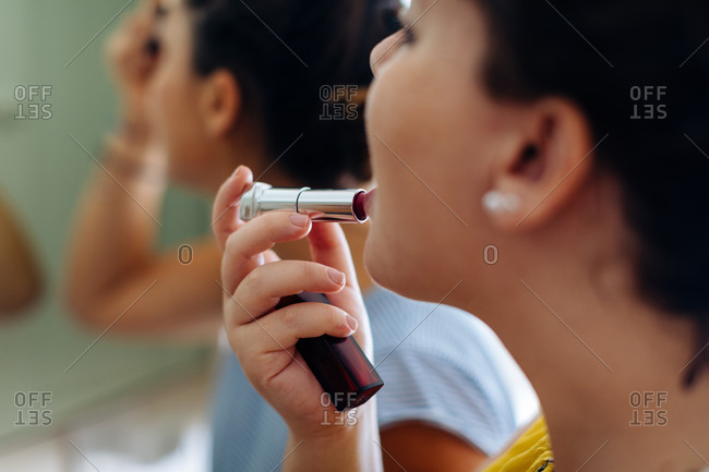 Friends putting on makeup at mirror