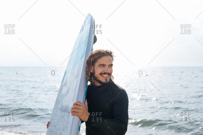 Surfer with surfboard by seaside