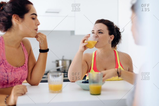 Friends enjoying juice at home after exercise