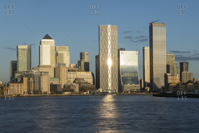View across the River Thames to tall buildings of Canary Wharf in East London.