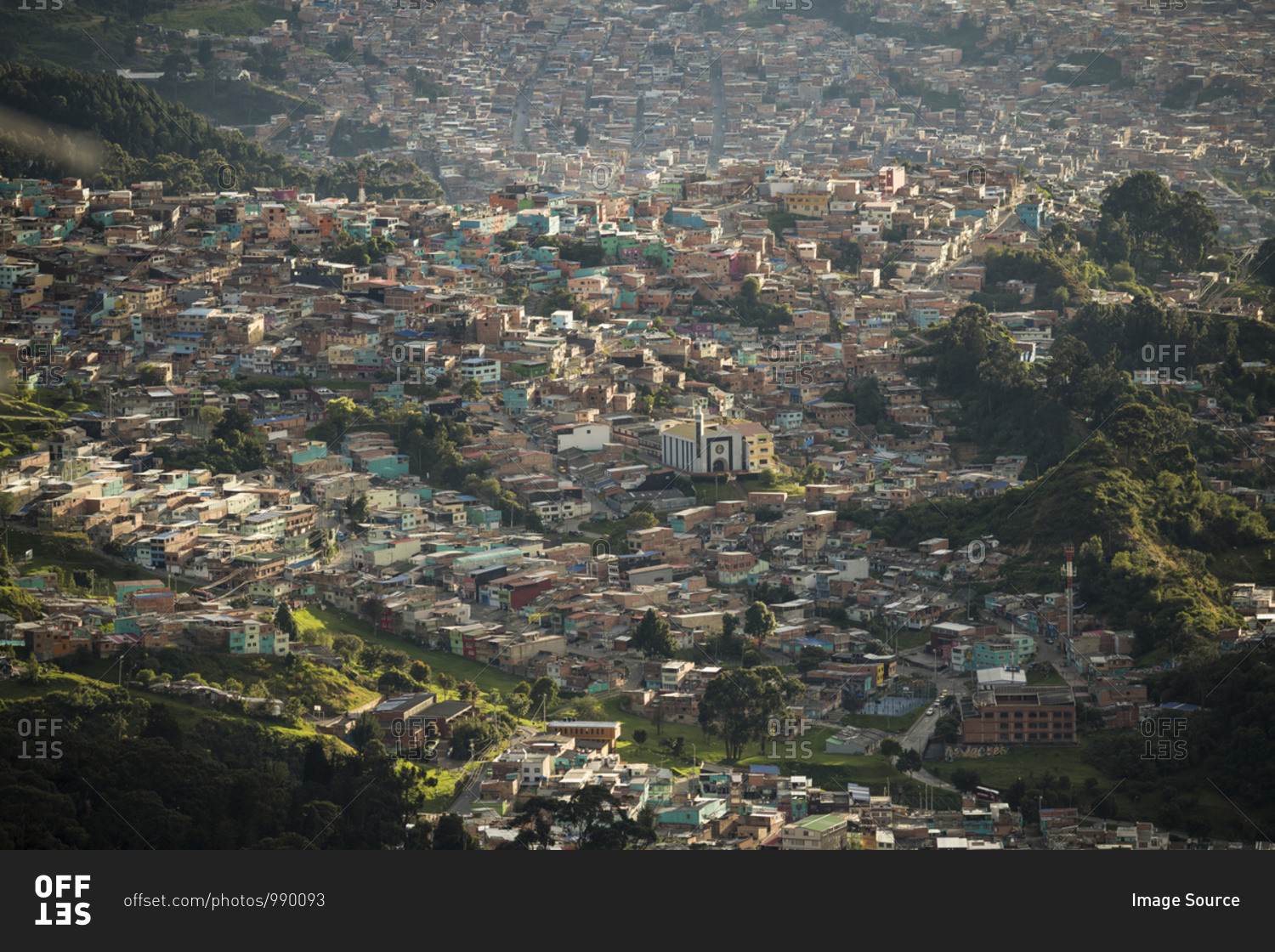 Elevated view of urban settlement, houses on the hillside and valley floor in mountains.