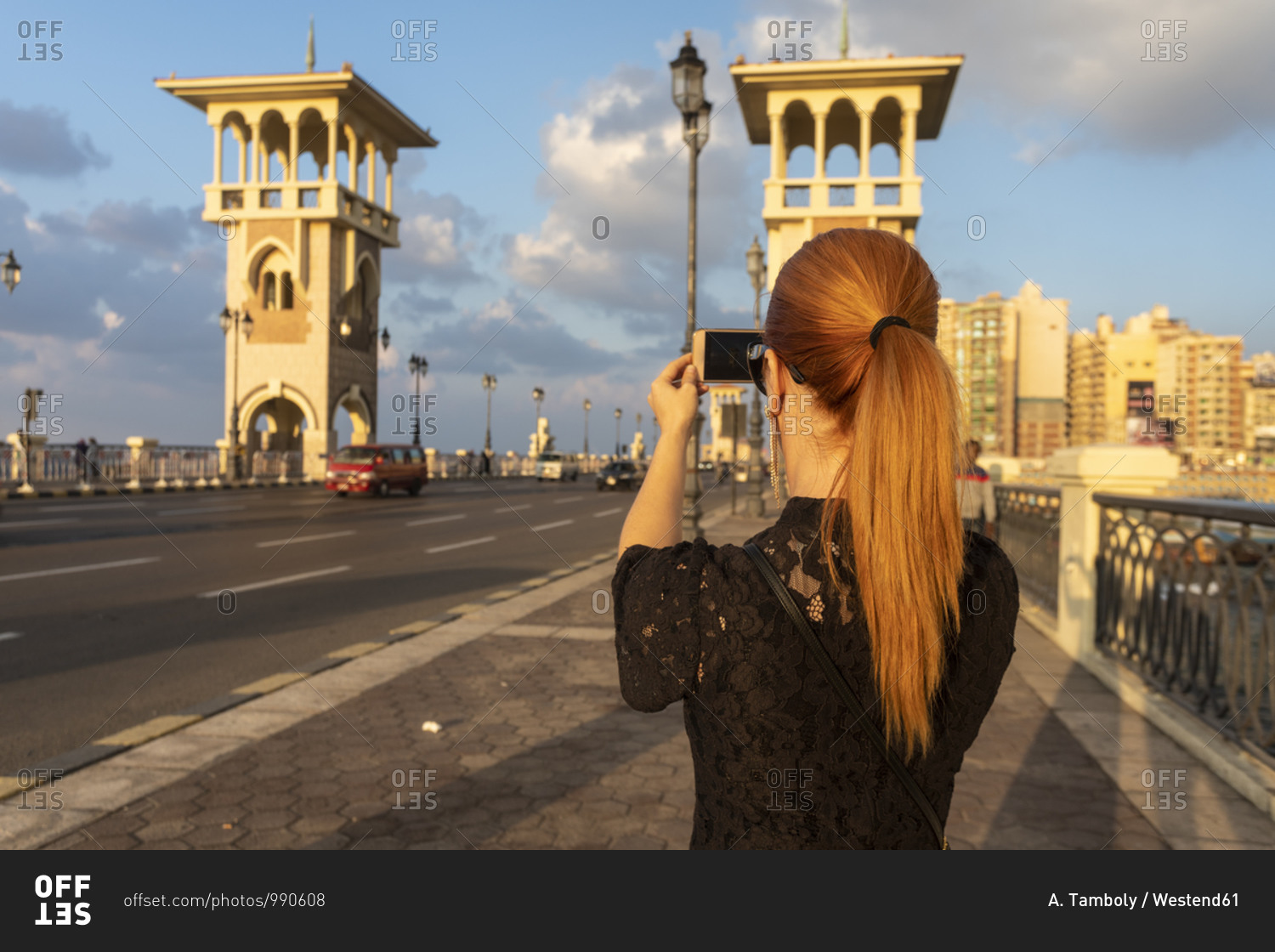 Egypt- Alexandria- Rear view of woman photographing Stanley bridge at sunset