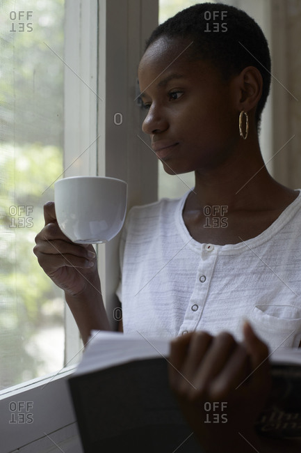 Close-up of a woman holding a cup of black coffee