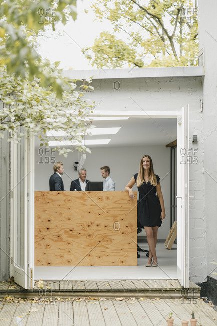 young woman opening office door stock photos - OFFSET