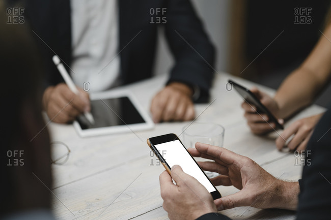 Business people working in office using portable devices- close up