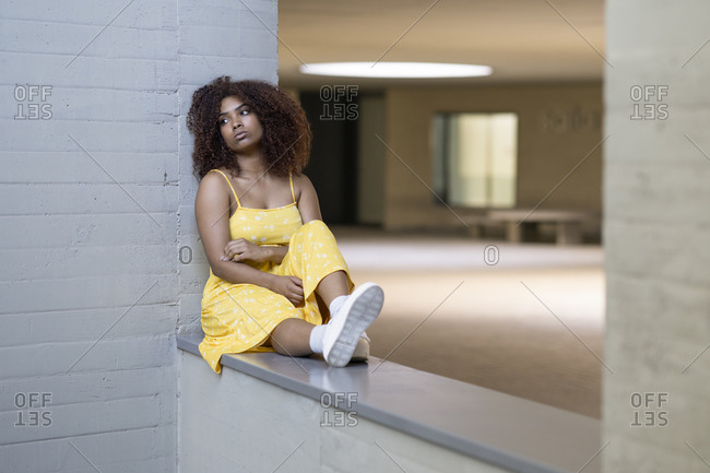 sad girl sitting against wall