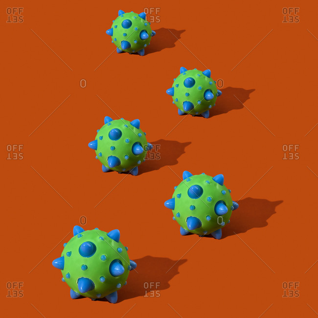 A representation of some SARS-CoV-2 virions, that cause the covid-19, on an orange background
