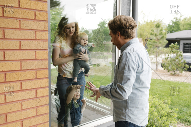 USA, Utah, Salt Lake City, Father visiting partner and children (6-11 months, 2-3) through window