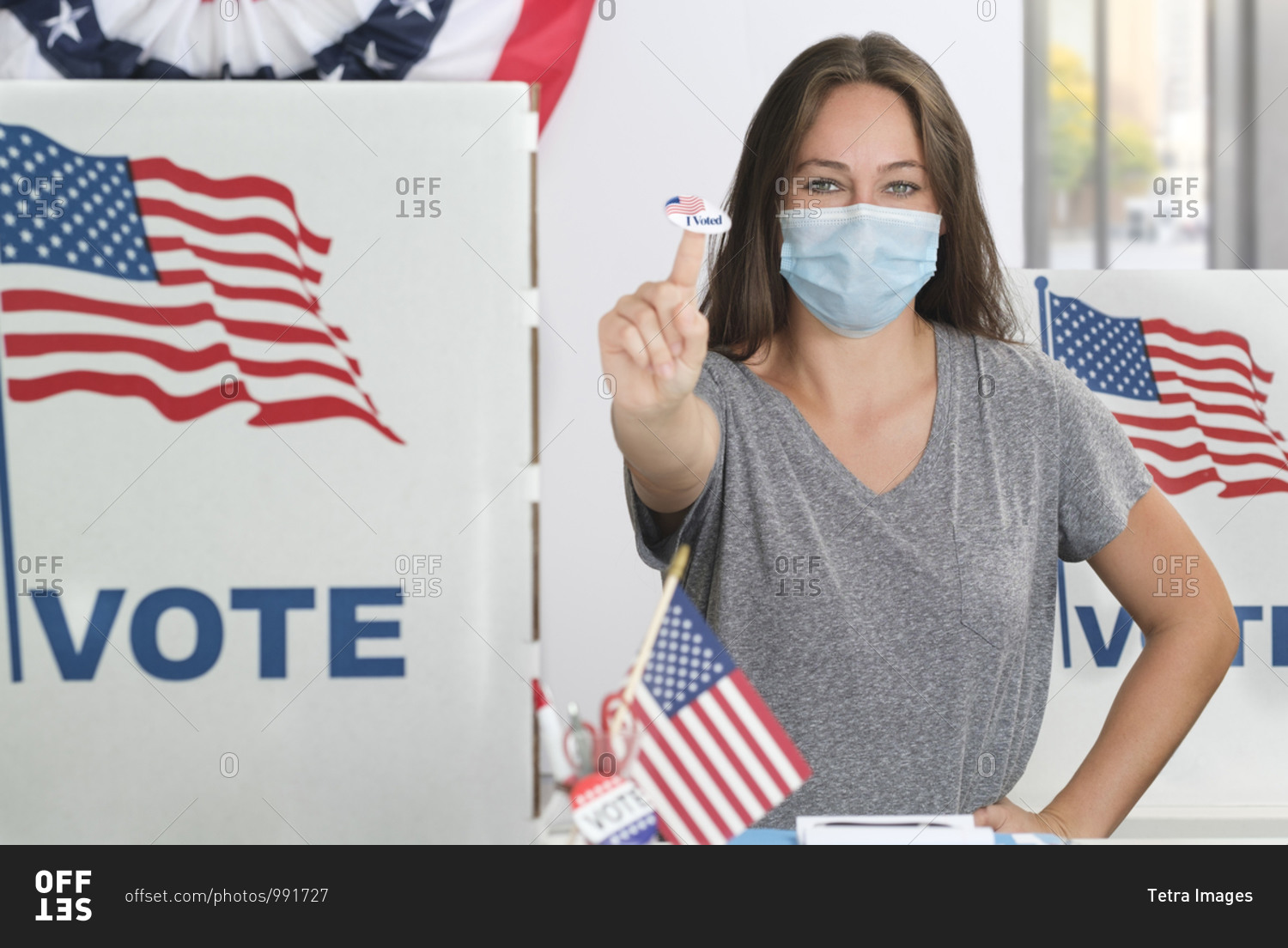 Woman in face mask holding voting sticker