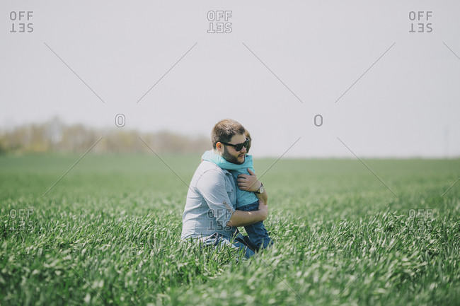 Father with son (2-3) in green field