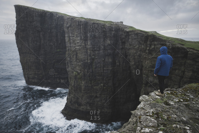 Denmark, Faroe Islands, Sorvagur, Person looking at sea coast with cliffs