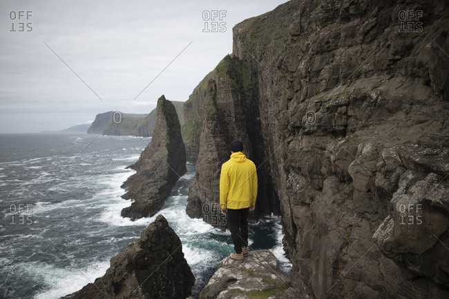 Denmark, Faroe Islands, Sorvagur, Man looking at sea coast with cliffs
