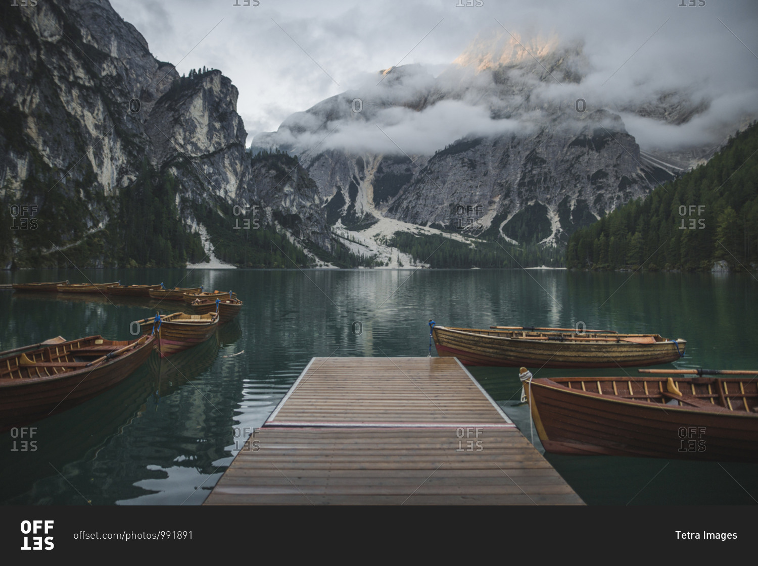 Italy, Wooden boats moored by pier at Pragser Wildsee in Dolomites