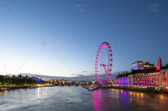 London, United Kingdom - July 10, 2020: The London Eye lit up pink during blue hour