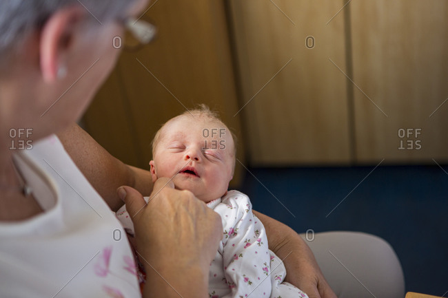 A woman holding sleeping newborn baby