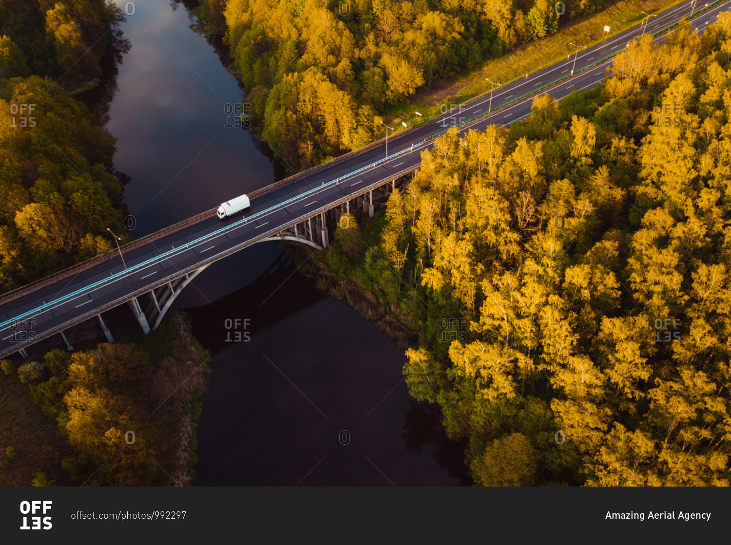 Aerial view of white cargo truck crossing bridge on highway near Kaunas, Lithuania.