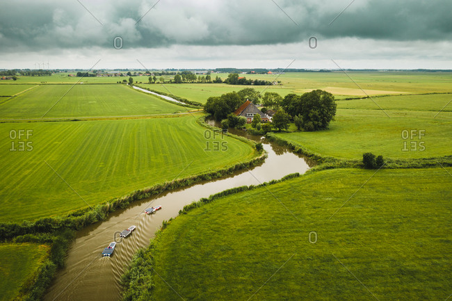 Aerial view of solar panel boats navigating through the farmlands in Bolsward, Friesland, The Netherlands.